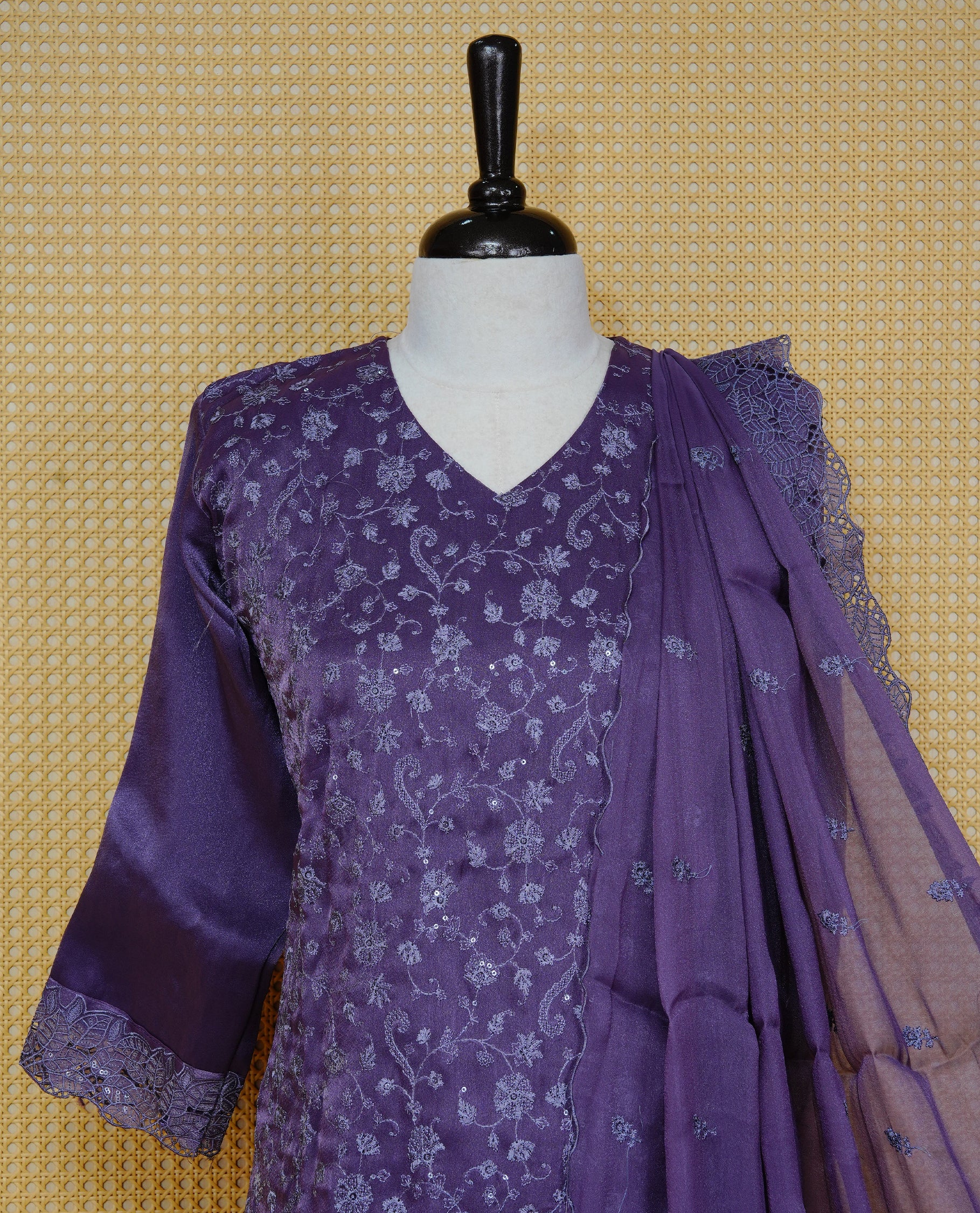 Greyish Purple colour churidar set with floral thread embroidery on body & V-neckline, paired with a matching embroidered dupatta and solid pants.
