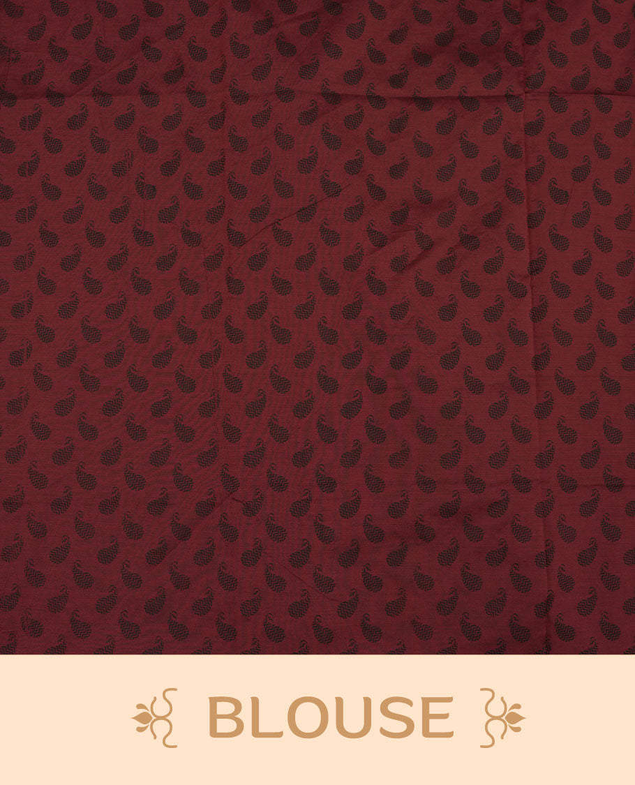 Deep maroon colour poly cotton saree with black floral butti motifs on the body, paired with a matching pallu featuring black ornate floral jaal and stripes on the border, and a coordinated all‑over black paisley printed blouse piece.