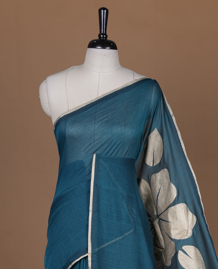 Green coloured mul cotton saree featuring bold gold-tone floral motifs across the body, designed without a border and comes without a blouse piece.