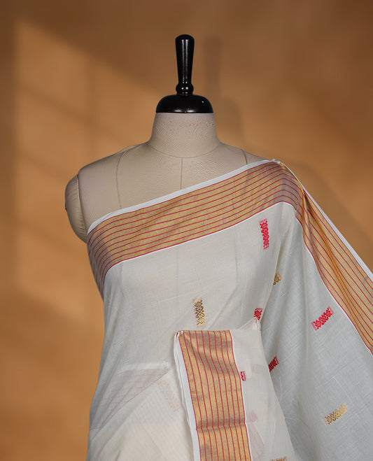 Off white colour cotton Kerala saree featuring subtle woven motifs, striped zari border with red detailing, and rich traditional zari pallu, paired with a matching blouse.