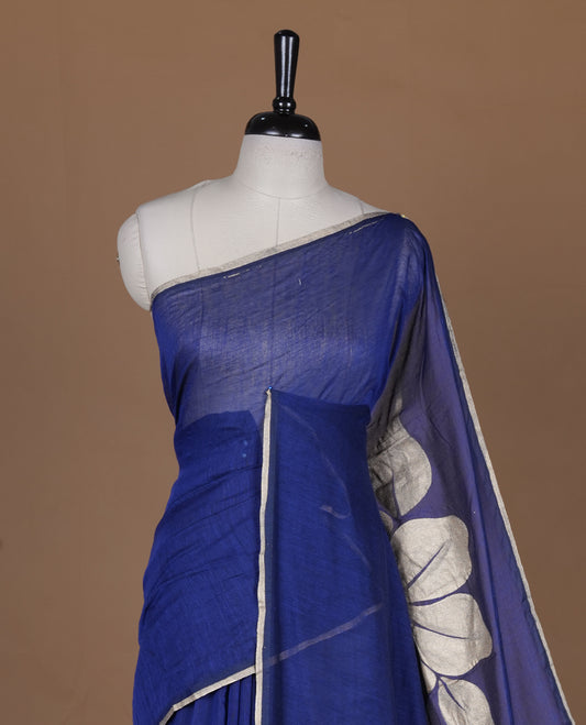 Blue coloured mul cotton saree featuring bold gold-tone floral motifs across the body, designed without a border and comes without a blouse piece.