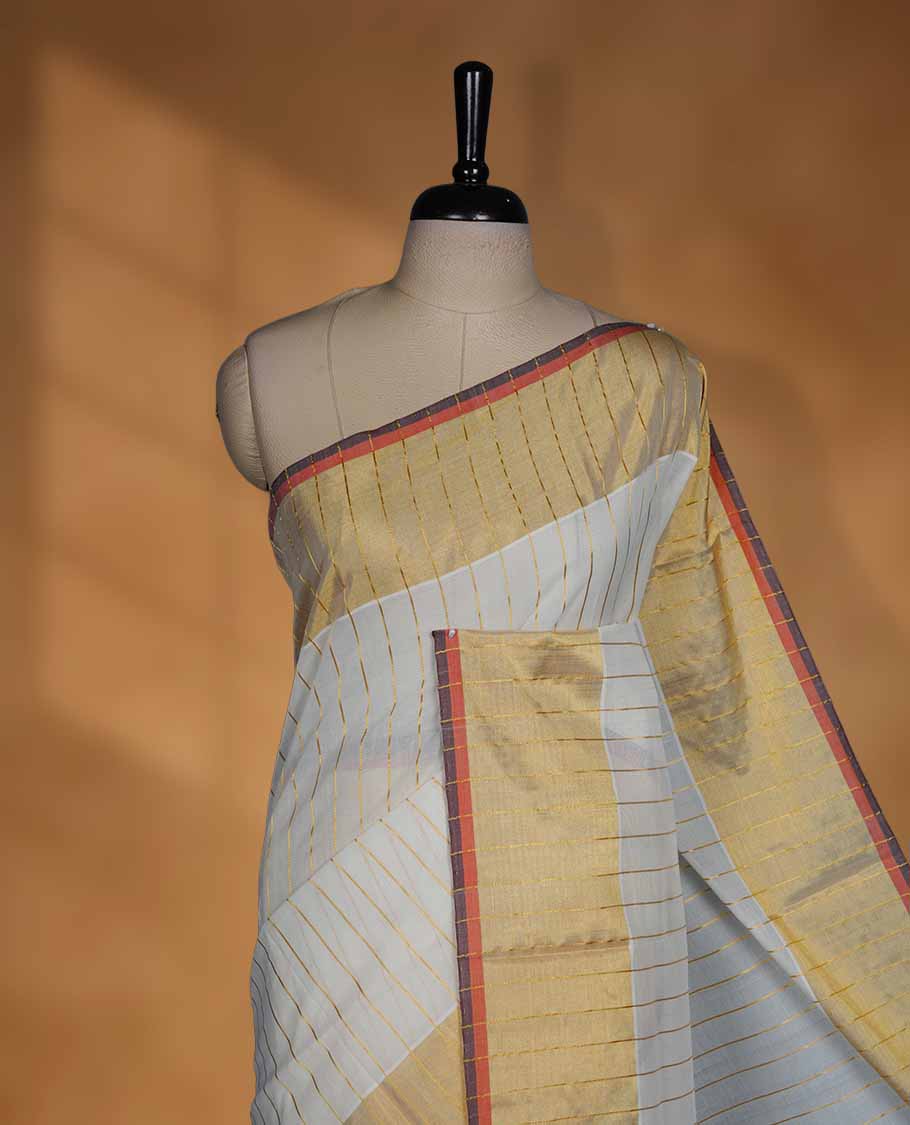 Off white Cotton Kerala saree with a striped body, wide golden zari border with orange and brown accents, and traditional pallu, paired with a matching blouse.