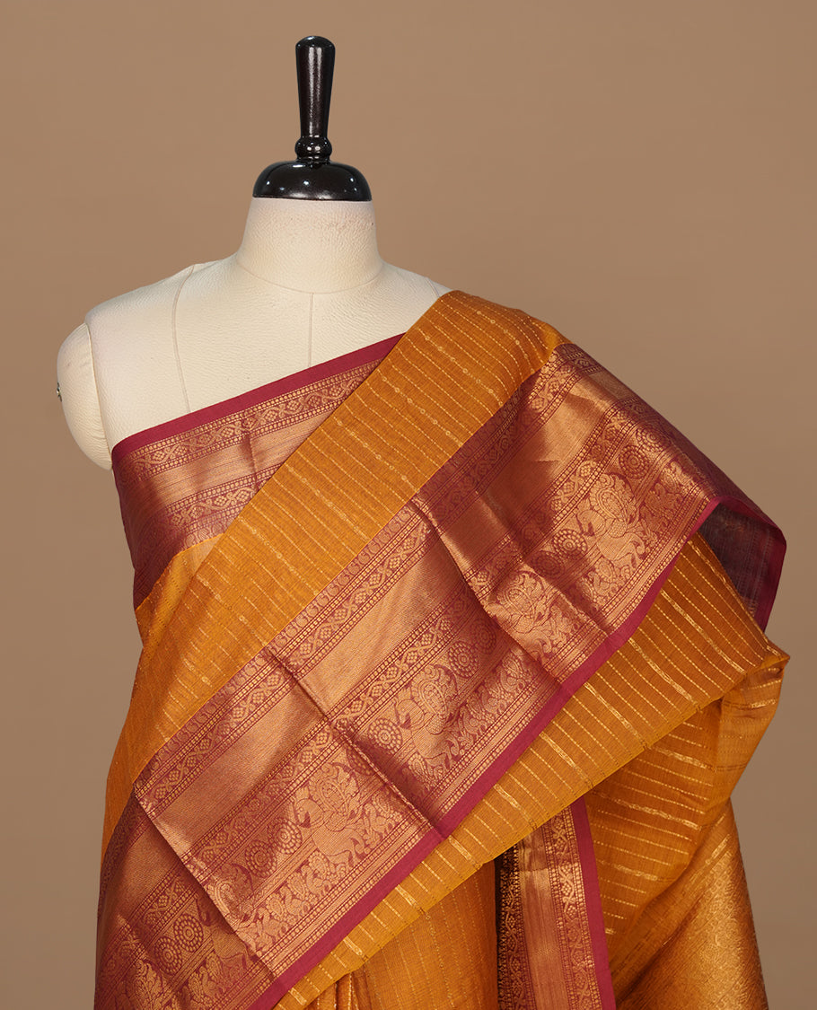 Mustard colour chettinad saree featuring gold zari stripes on body, complemented by contrast Maroon colour with traditional border, paired with matching blouse piece.