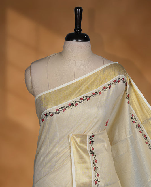 Off white colour Tissue Kerala saree featuring delicate floral border detailing, complemented by a classic golden zari border and traditional pallu, paired with a matching blouse.