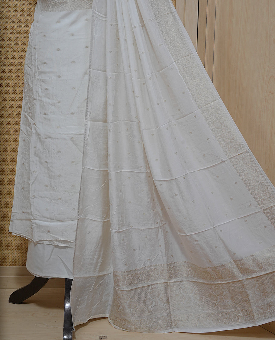 Cream colour Salwar material featuring gold zari Buttas on body & zari worked Neck Portion, paired with matching dupatta & Bottom.