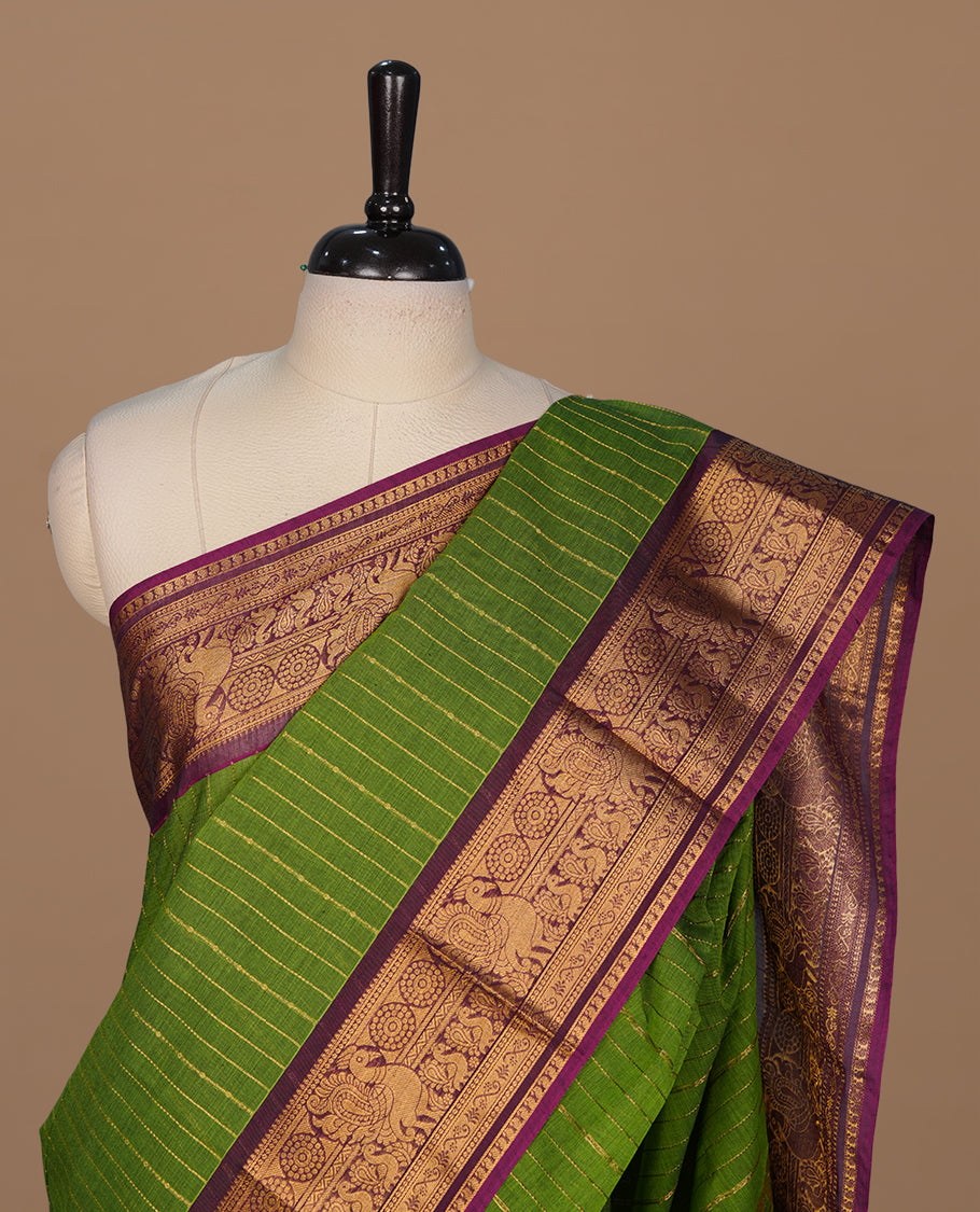 Lemon green colour chettinad cotton saree featuring gold zari stripes on body, complemented by contrast magenta colour with gold zari border, paired with matching blouse piece.