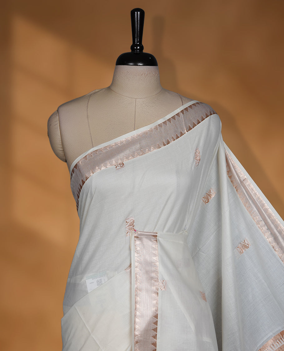 Off white colour cotton Kerala saree featuring a Plain body, a refined light copper zari border, and an intricately woven traditional pallu, paired with a matching blouse.