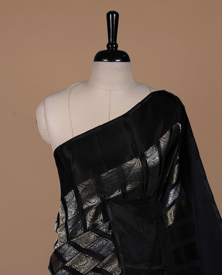 Black colour banaras crepe saree featuring gold & silver zari design stripes on body, complemented by self colour border, paired with matching blouse piece.