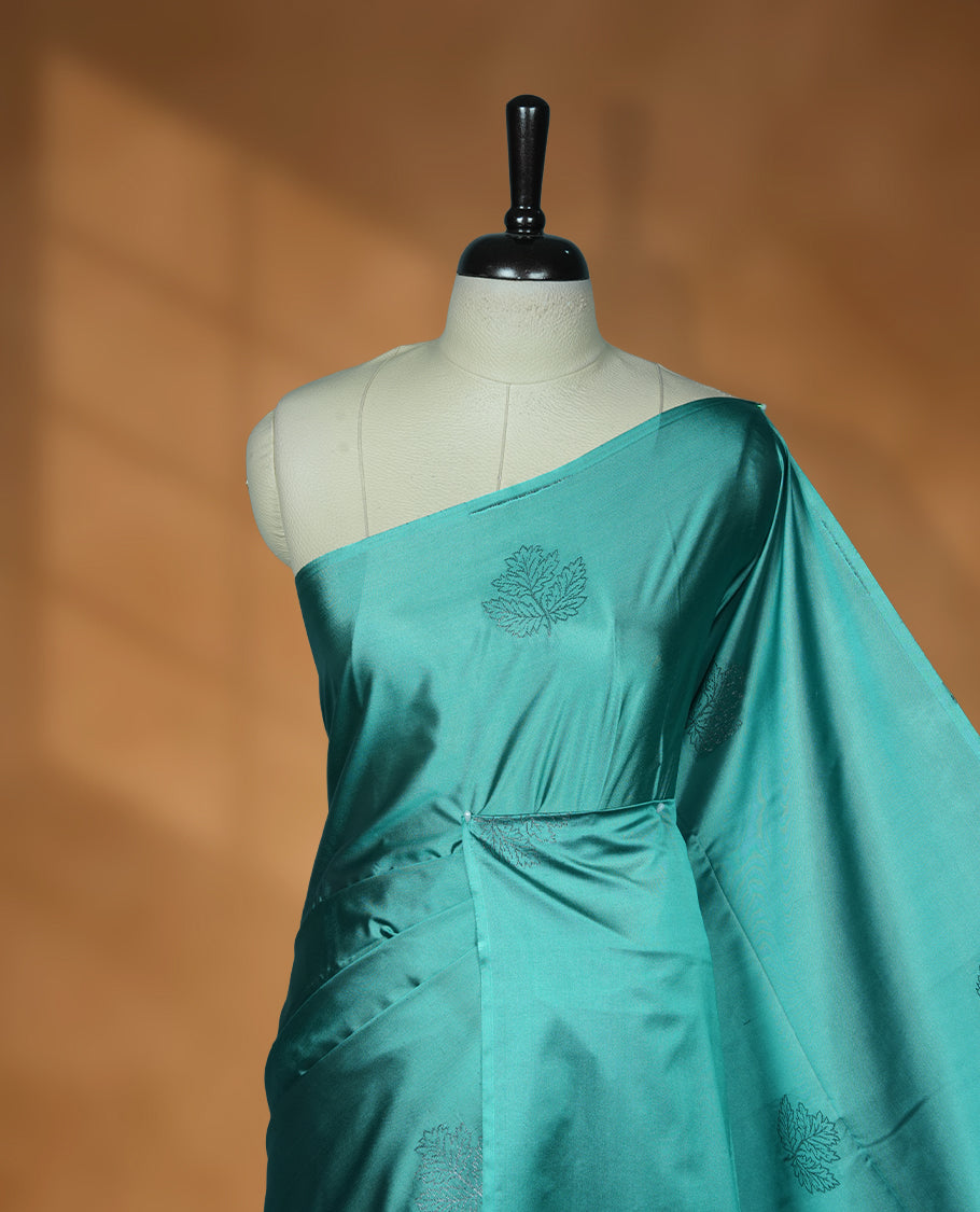 Teal colour soft silk saree featuring Antique zari motifs on body with Highlighting contrast Plum purple colour pallu and paired with matching blouse piece.