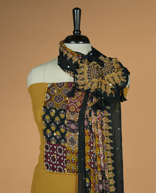 Mustard colour georgette salwar suit collection featuring plain body enhanced with elegant black bunch kalamkari print on neck yoke, detailed with subtle mirror work , paired with kalamkari printed dupatta with mirror work with santon material bottom.