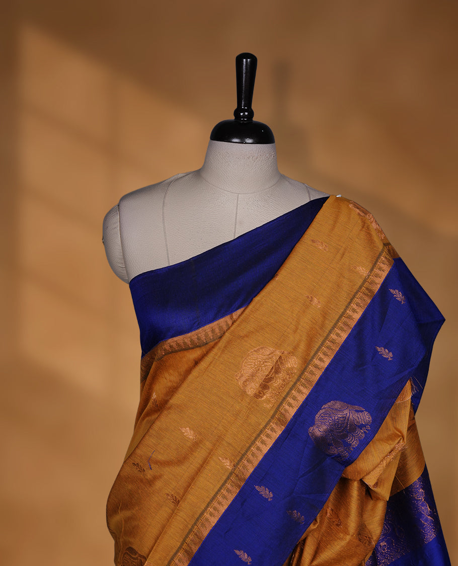 Mustard colour mixed Kalyani cotton saree with subtle zari motifs, royal blue zari border and elephant motif pallu, paired with a matching blouse.