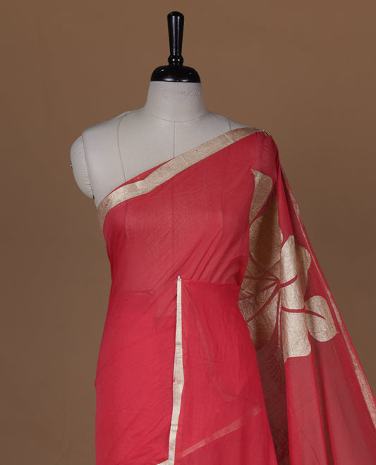 Red coloured mul cotton saree featuring bold gold-tone floral motifs across the body, designed without a border and comes without a blouse piece.