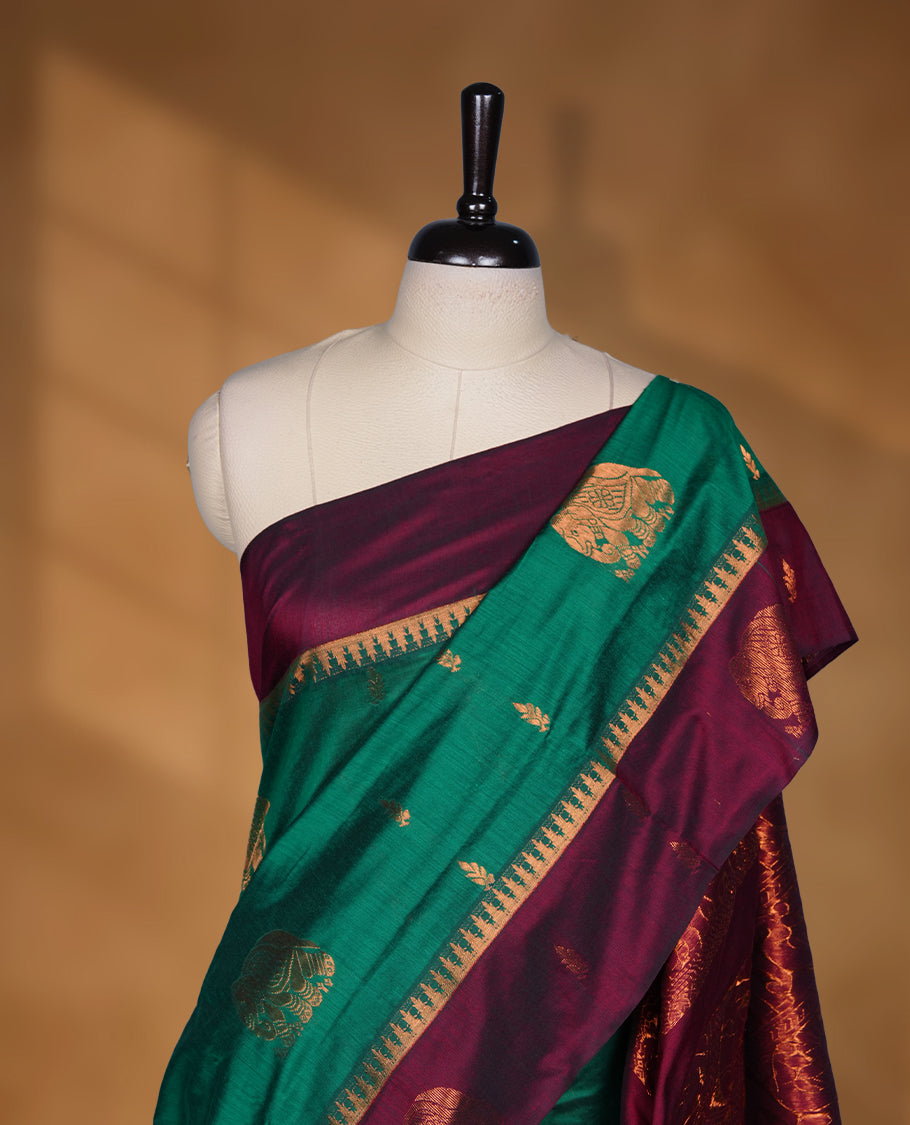 Dark Green colour mixed Kalyani cotton saree with zari motifs on the body, maroon zari border and traditional elephant motif pallu, paired with a matching blouse.