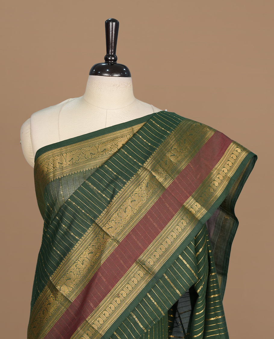 Green colour chettinad cotton saree featuring gold zari stripes on body, complemented by gold zari with maroon border, paired with matching blouse piece.