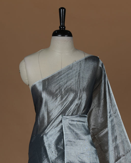 Silver colour semi tissue saree featuring an elegant plain body, designed without a border and comes without a blouse piece.