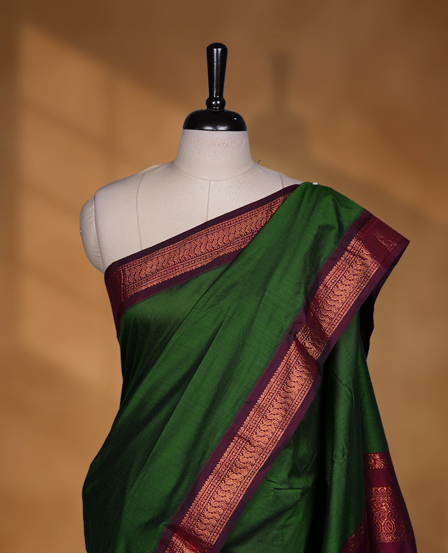 Green colour Kalyani cotton saree featuring a plain elegant body, complemented by a rich maroon zari border and traditional woven pallu, paired with a matching blouse.