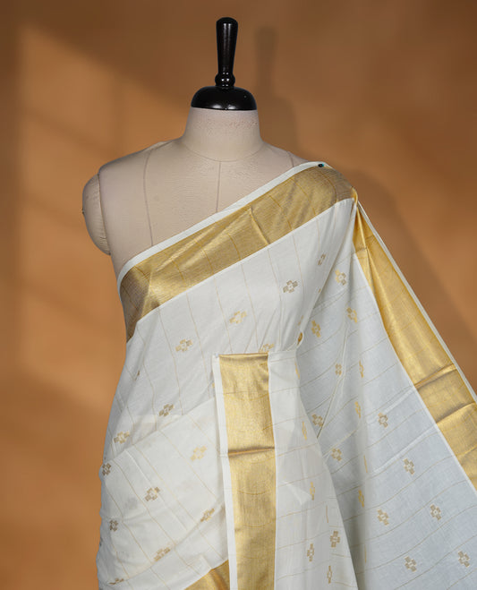 Off white colour cotton Kerala saree featuring a stripes and small buttas on body, a refined kasavu border, paired with a matching blouse.