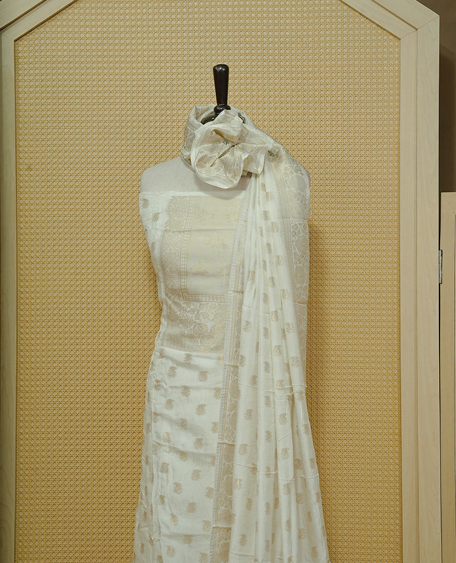 Cream colour Salwar material featuring gold zari Buttas on body & zari worked Neck Portion, paired with matching dupatta & Bottom.