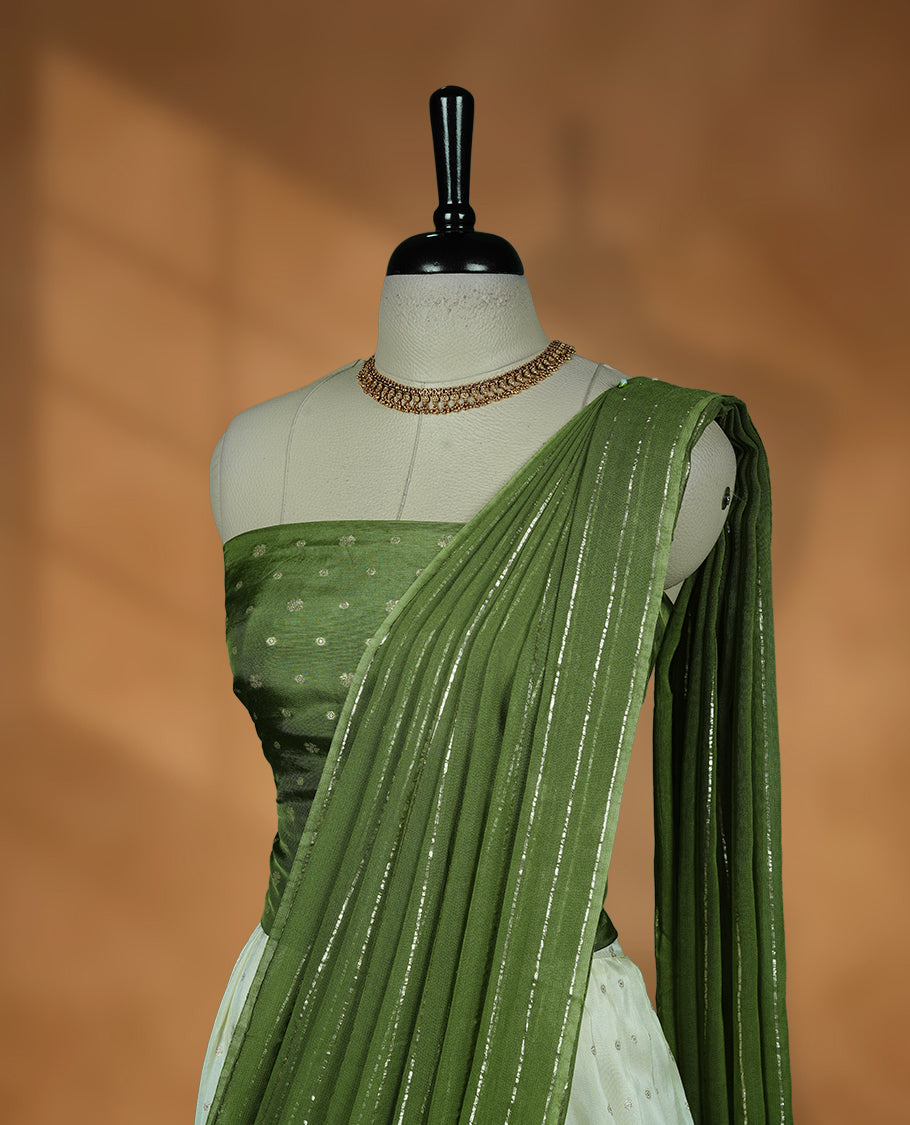 Off white semi banaras semi stitched dhavani set featuring gold zari motifs and contrast green colour border, unstitched gold zari blouse piece and matching Duptta with gold zari stripes.