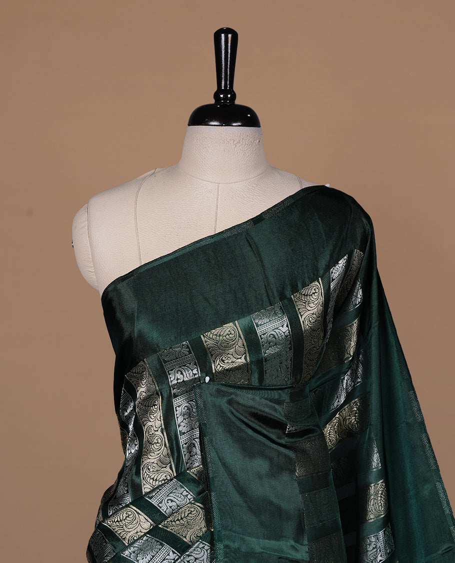 Green colour banaras crepe saree featuring gold & silver zari design stripes on body, complemented by self colour border, paired with matching blouse piece.