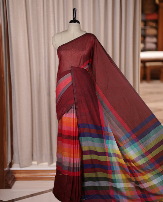 Maroon colour soft cotton saree with rainbow colored horizontal lines on the body, a vibrant multicolor pallu, and a subtle border & Elegant and lightweight, this saree comes without a blouse piece for a customizable style.