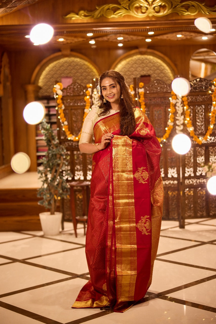 Red colour Kancheepuram Silk saree with Golg Zari Checks design, Rettai peacock motifs on border and pallu, paired with matching blouse piece.