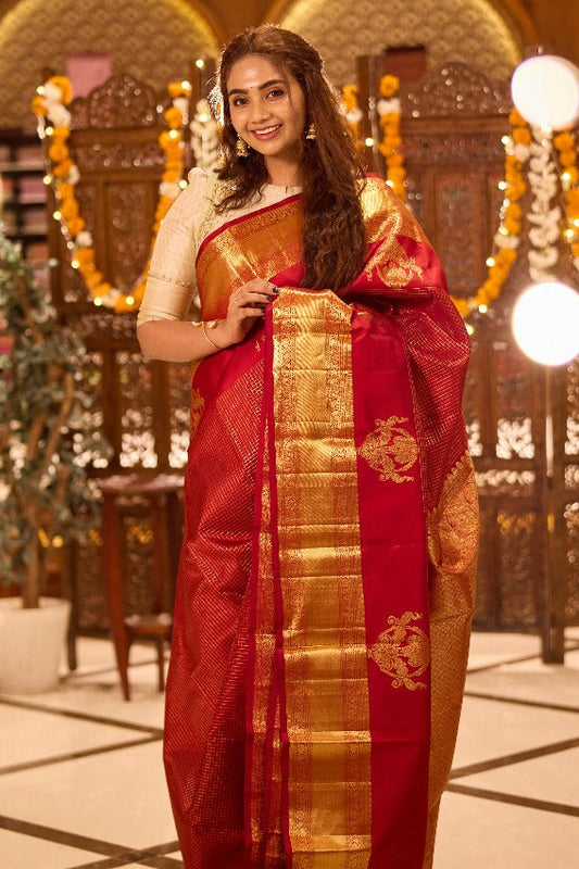 Red colour Kancheepuram Silk saree with Golg Zari Checks design, Rettai peacock motifs on border and pallu, paired with matching blouse piece.