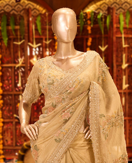 Dusty Gold colour tissue organza designer saree featuring delicate Floral embroidery and beadwork across the body, finished with heavy embellished border and pallu, paired with a matching tissue organza designer readymade blouse.