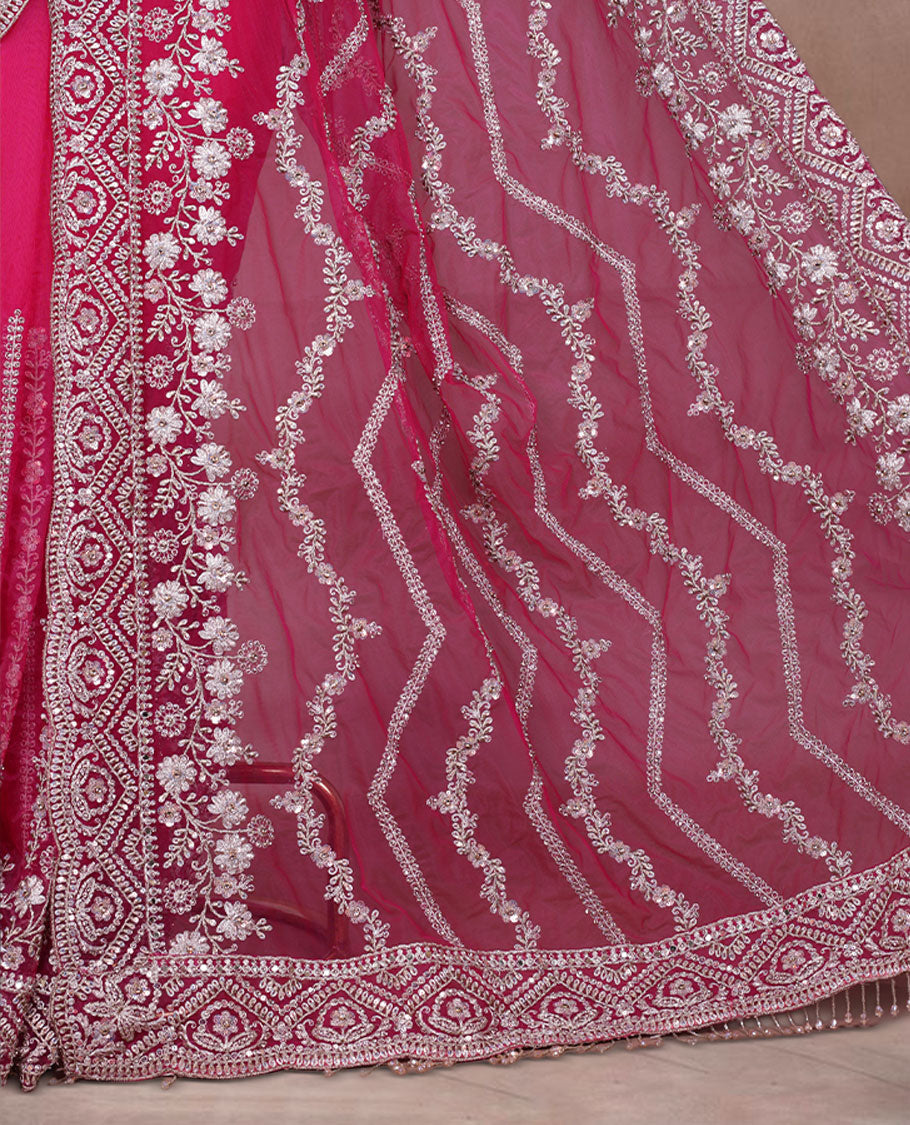 Rani Pink Colour net designer Wedding saree featuring all over floral embroidery with sequin detailing and an ornate scalloped border, finished with a matching embellished blouse.