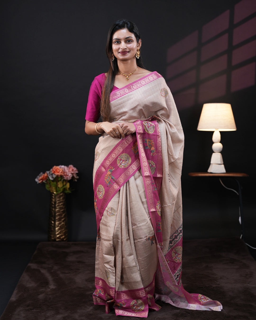 Cream Colour Moss chiffon saree featuring gold zari checks with elephant & peacock prints on the body, Pink Colour double border with elephant prints and a contrast designed pallu, paired with a contrast designed blouse piece.