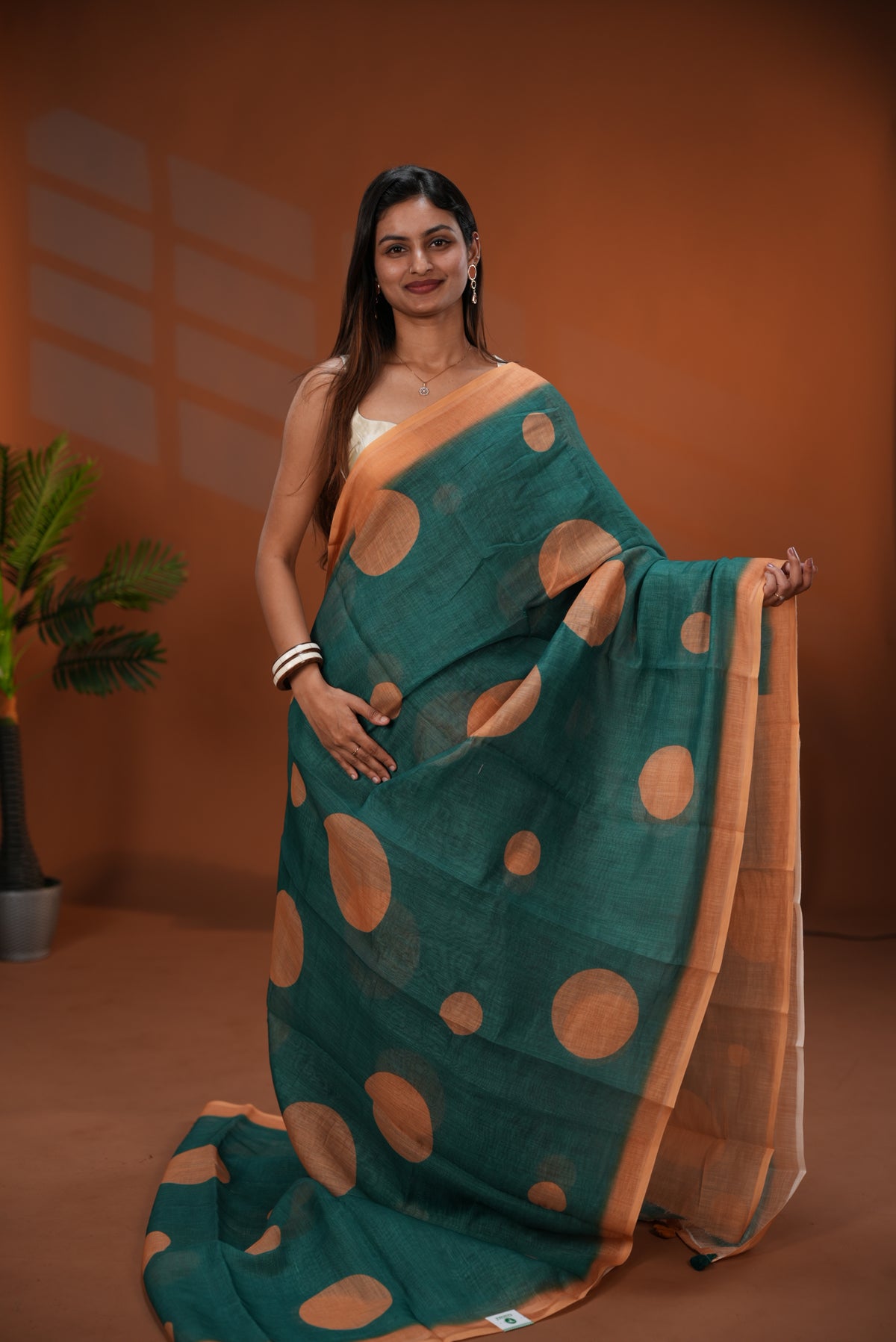 Dark Green colour Linen saree featuring Gold Polka dot on body, Contrast Border and Blouse.