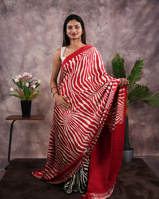 Red Colour satin model saree featuring Zibra print on body. Ajrak & zibra print on pallu with jhumka tassels, comes with contrast plain blouse piece.