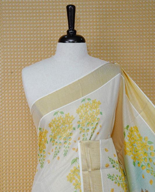 Cream Colour Tissue Kerala Saree Featuring Vibrant Digital Krishna & Radha Onam Theme  Printed Pallu, Beautifully Enhanced With A Classic Gold Zari Border And Contrast Tassels. Paired With A Matching Blouse Piece.