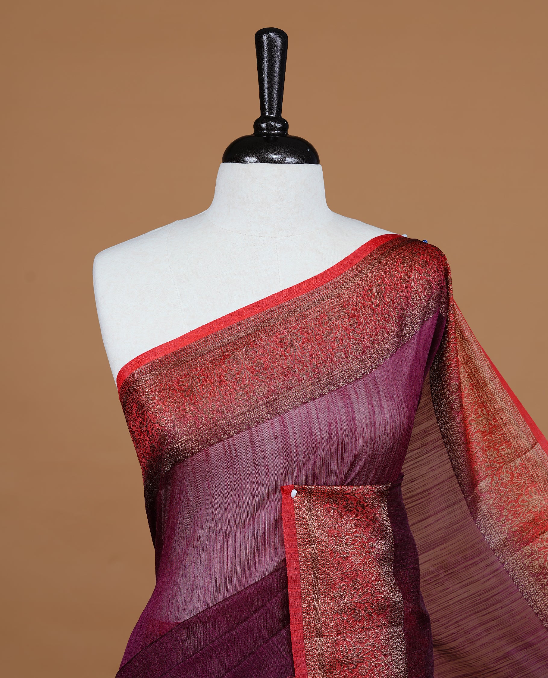 Maroon colour Semi linen saree featuring Elegant plain body, complemented by contrast Red colour With Antique zari border, paired with matching blouse piece.
