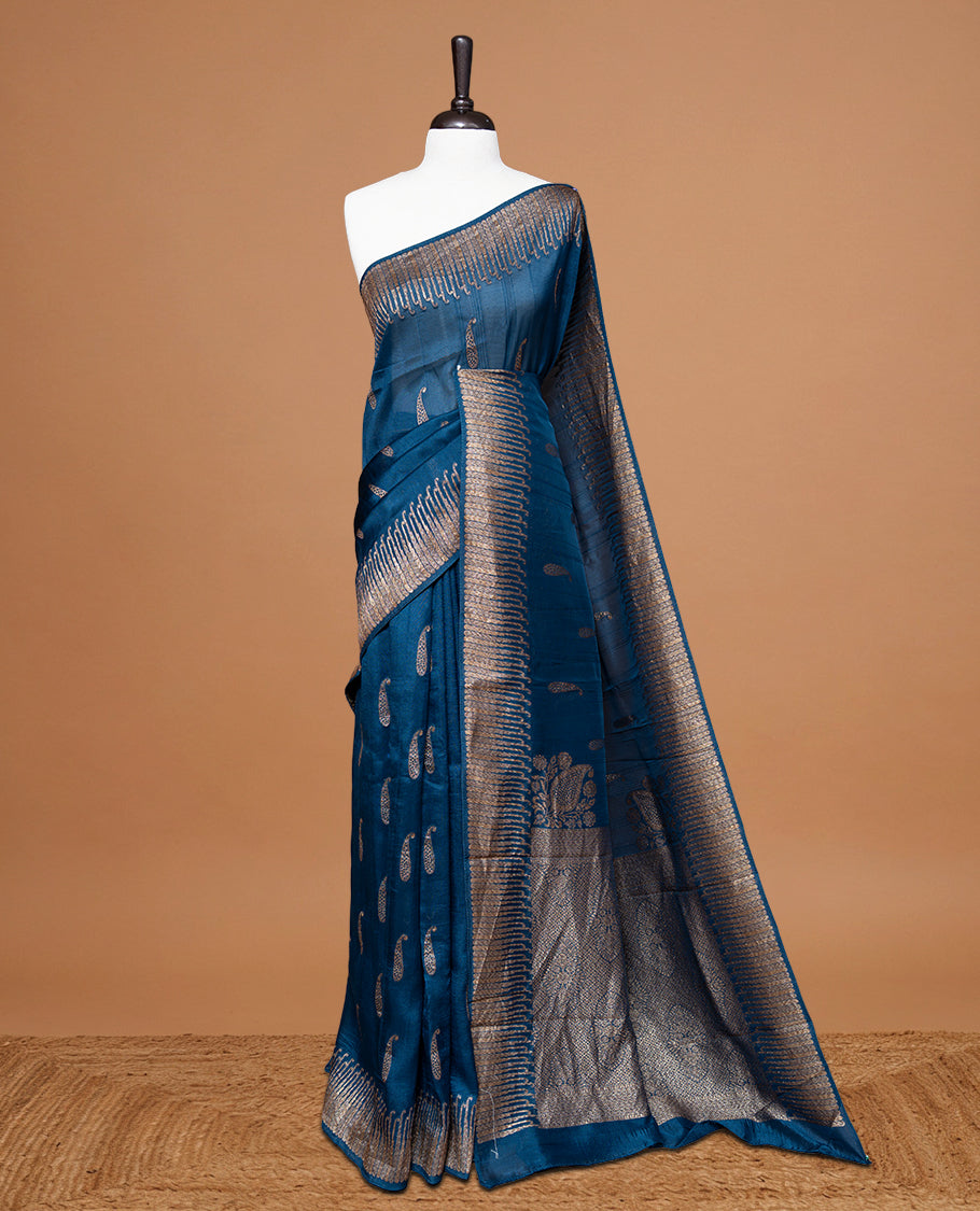 Blue colour Semi Banaras Tussar Georgette Featuring Gold zari Leaf pattern on body, Finished with Gold zari border and paired with matching blouse piece.
