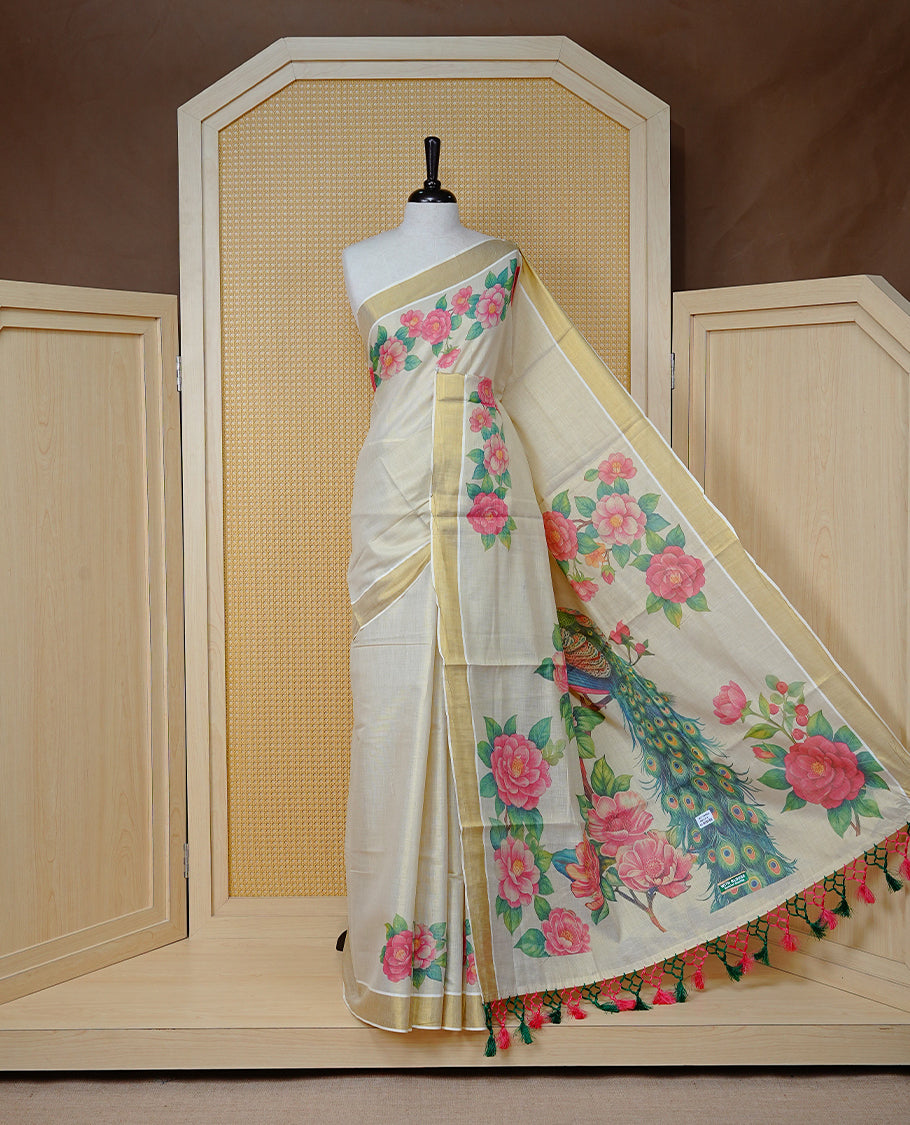 Cream Colour Tissue Kerala  Saree Featuring A Digital Peacock Floral Printed Body, Highlighted With Classy Gold Zari Border Green &  Coral Pink  Tassel At Pallu, Paired With A Matching Blouse Piece.