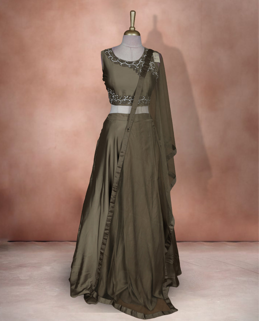 Olive brown colour lehenga set with stitched sleeveless embroidered blouse, matching stitched flared lehenga, and plain sheer dupatta with satin border.