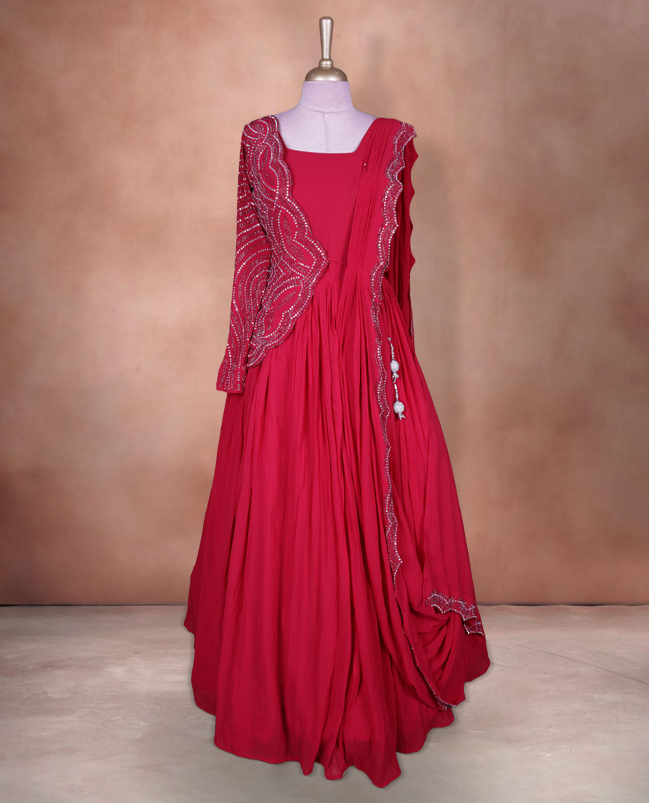 Rani pink colour stitched gown set with square neckline, attached pleated flare, and one‑side draped dupatta highlighted with heavy silver sequin and mirror work border and sleeve.