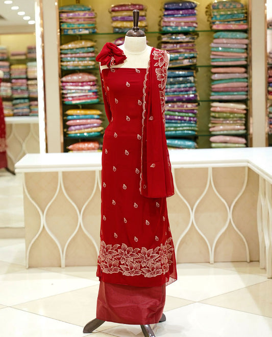 Red colour georgette salwar set featuring gold zari buttas on body, floral embroidery and scalp work on dupatta, paired with matching bottom.