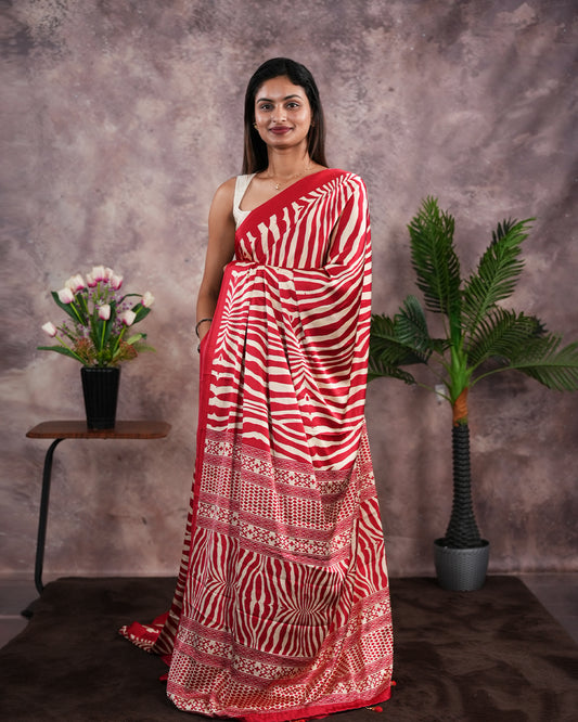Red Colour satin model saree featuring Zibra print on body. Ajrak & zibra print on pallu with jhumka tassels, comes with contrast plain blouse piece.