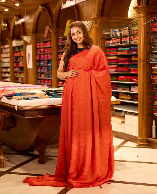 Orange colour viscose saree in rich teal shade featuring a subtle sheen and lightweight drape, enhanced with satin piping finished border, paired with a matching blouse piece