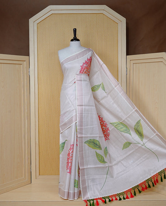 Cream Colour Tissue Kerala  Saree Featuring A Digital Floral Printed Body &  Pallu, , Beautifully Enhanced With A Classic  Rose Gold Zari Border And Red &  Green  Tassels, Paired With A Matching Blouse Piece.