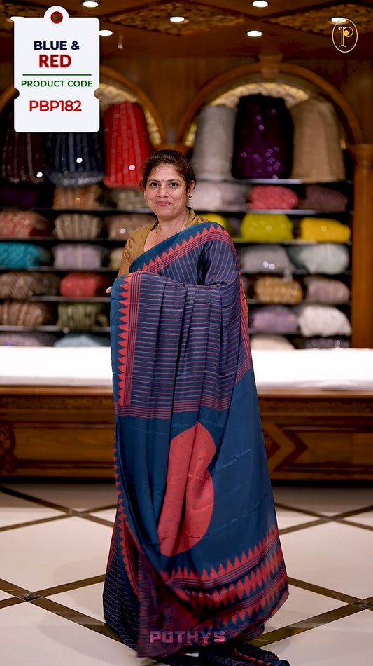 Blue semi modal saree featuring red vertical line prints, accented with a contrasting temple border and a bold circular motif on the pallu, paired with a matching printed blouse.