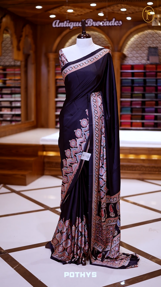 Black Semi modal silk saree featuring traditional Ajrakh print with intricate motifs and contrast borders, paired with a perfectly matching blouse & A timeless piece blending heritage with grace.