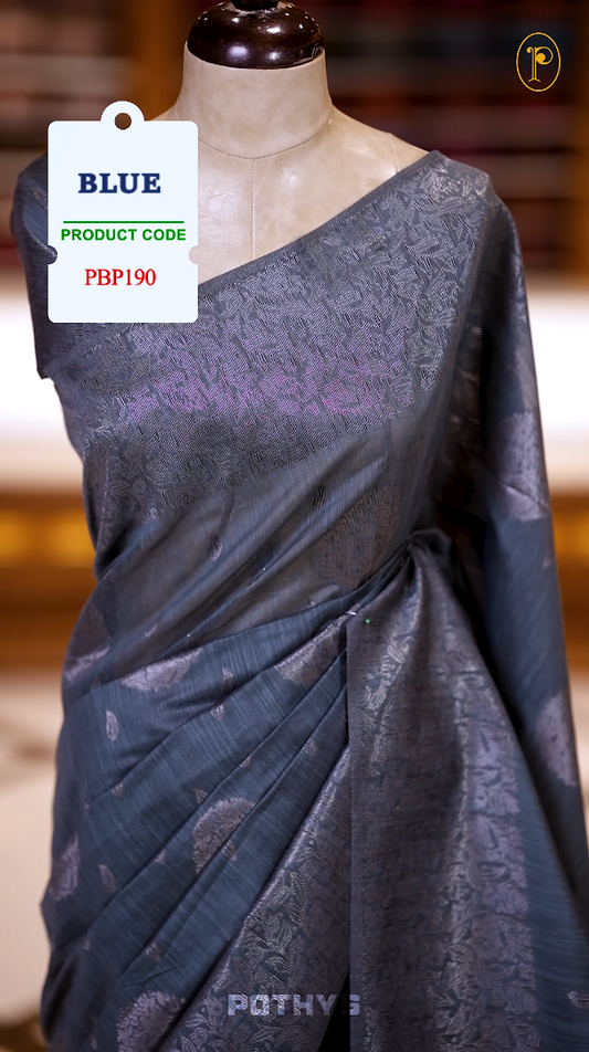 Teal Blue colour semi silk saree with a stunning silver thread border and intricate leaf design & Comes with a perfectly matching blouse piece, ideal for festive and formal occasions.