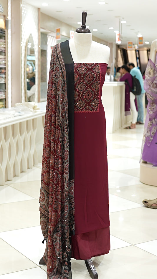 Maroon Georgette salwar material featuring Ajrakh print with mirror work on the yoke, paired with Ajrakh printed dupatta with mirror detailing and plain bottom.