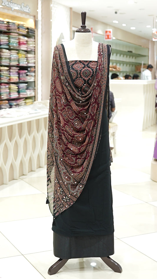 Black Georgette salwar material featuring Ajrakh print with mirror work on the yoke, paired with Ajrakh printed dupatta with mirror detailing and plain bottom.
