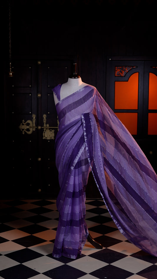 Violet Mul Mul cotton saree adorned with subtle silver stripes across the body and finished with a delicate silver zari border.