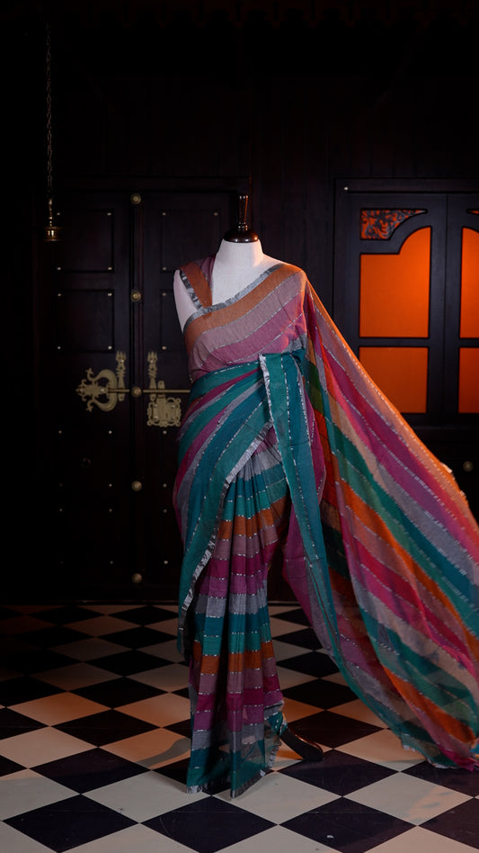 Purple colour Mul Mul cotton saree adorned with subtle silver stripes across the body and finished with a delicate silver zari border.