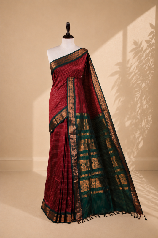 Maroon colour kalyani cotton saree featuring gold zari check pattern on body, complemented by green colour with Antique zari border, paired with matching blouse piece.